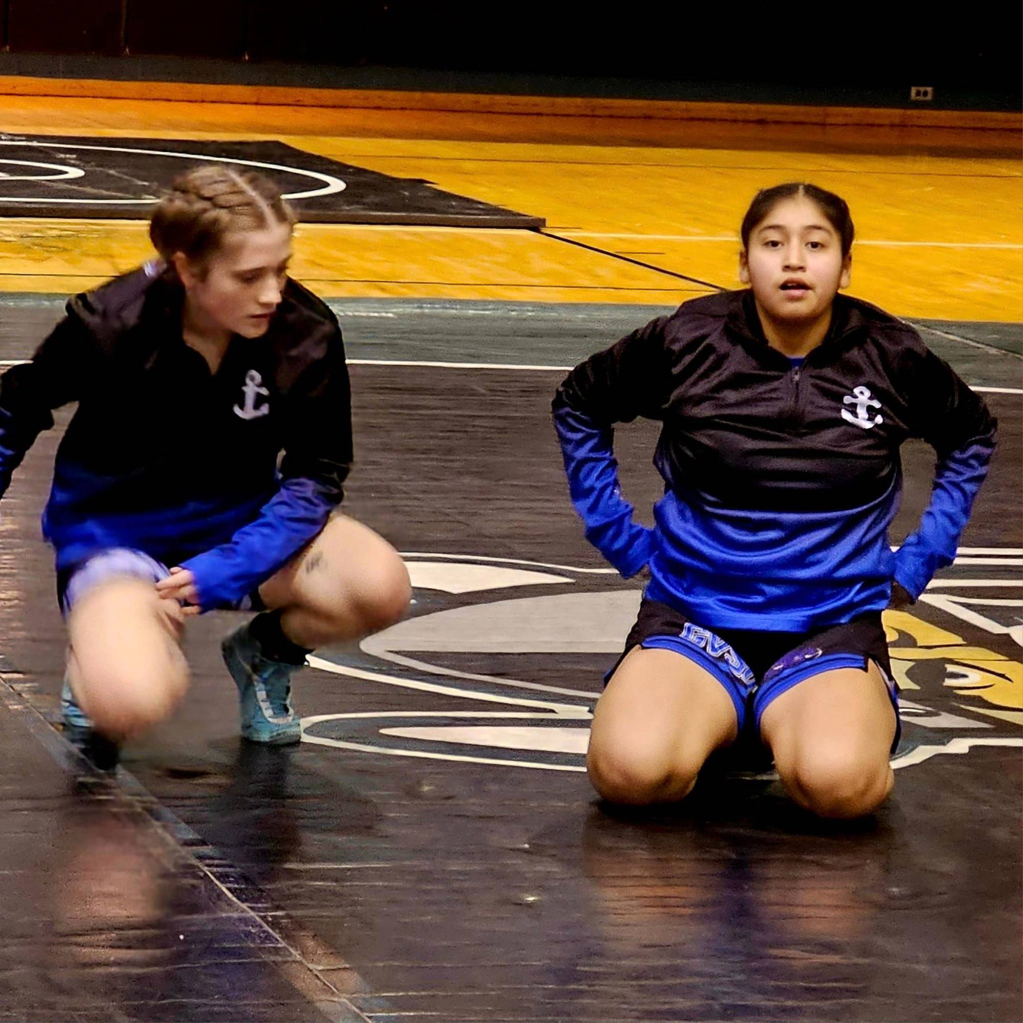 softball player crossing home plate with teammates cheering around her and all hands on her helmet